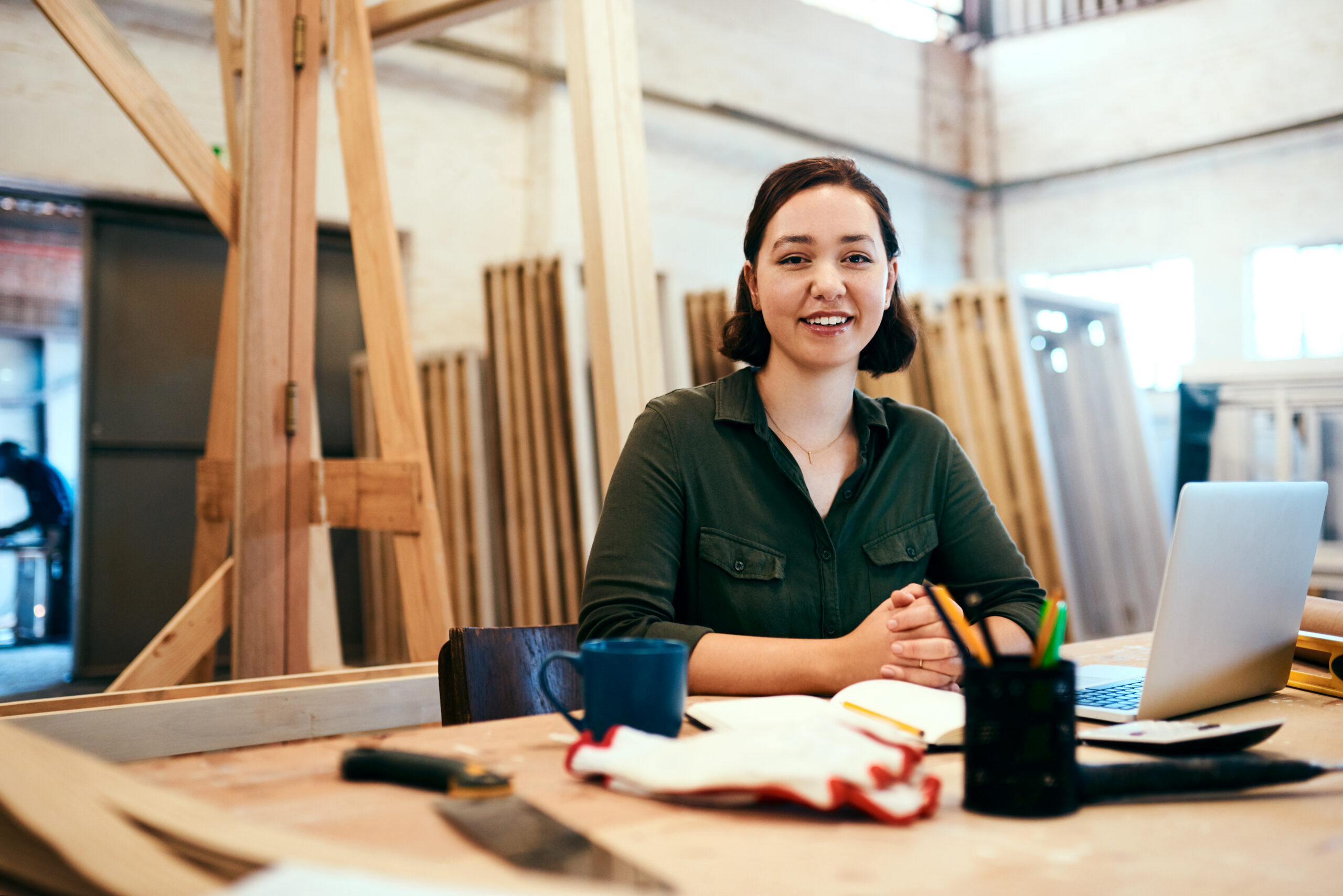 Female carpenter sitting at her desk in a workshop
